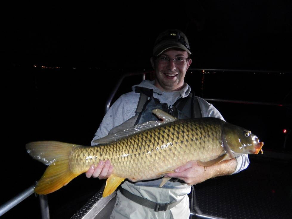 Alan Mock holds a large carp for the camera.